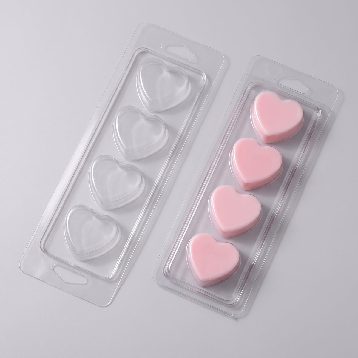Matriță clam shell 4 inimi pentru wax melts, tavă goală lângă tavă turnată cu ceară roz